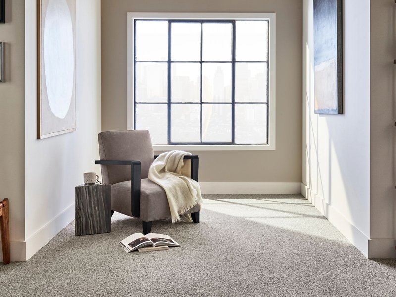 Gray armchair next to a window in a room with gray carpet from Brennan's Carpet in Hailey, ID